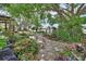Landscaped gardens with stone pathway, heron statues, plants, flowers, and a big tree at 2427 Beck Cir, Deltona, FL 32738