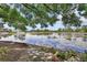 Lakeside view of the house featuring a stone pathway, plants, flowers, and beautiful water views at 2427 Beck Cir, Deltona, FL 32738