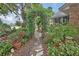 An enchanting landscaped yard with a vine-covered archway creates a serene and inviting outdoor space at 2427 Beck Cir, Deltona, FL 32738