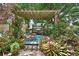 Wooden pergola with cozy seating, surrounded by lush greenery, plants, and flowers at 2427 Beck Cir, Deltona, FL 32738