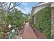 Side yard showcasing mature trees, brick pathway, ground cover, and manicured plants along the home at 2427 Beck Cir, Deltona, FL 32738