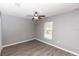 Bedroom with ceiling fan, a window, and wood look laminate at 2466 Candlewick St, Deltona, FL 32738