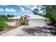 Charming single-story home with well-maintained landscaping, a brick walkway, and a two-car garage at 2466 Candlewick St, Deltona, FL 32738