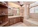 Elegant bathroom with a soaking tub and large vanity with warm wood cabinets at 2542 S Peninsula Dr, Daytona Beach, FL 32118