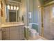 Bright bathroom features a glass shower, beige cabinets, and decorative lighting at 2542 S Peninsula Dr, Daytona Beach, FL 32118