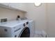 Clean laundry room with front-load washer, dryer, and white cabinets at 2542 S Peninsula Dr, Daytona Beach, FL 32118