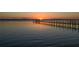 Stunning sunset reflecting on the calm water, highlighting a wooden pier extending into the tranquil scenery at 2542 S Peninsula Dr, Daytona Beach, FL 32118