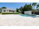 Swimming pool and patio, surrounded by garden and palms on a sunny day at 2542 S Peninsula Dr, Daytona Beach, FL 32118
