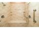 Neutral walk-in shower featuring a built-in bench, grab bars, and hand-held shower head at 2542 S Peninsula Dr, Daytona Beach, FL 32118