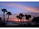 Picturesque sunset view over the water, framed by silhouetted palm trees, creating a serene tropical atmosphere at 2542 S Peninsula Dr, Daytona Beach, FL 32118
