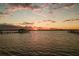 Golden sunset view featuring calm waters and a pier, enhanced by the vibrant sky and tranquil setting at 2542 S Peninsula Dr, Daytona Beach, FL 32118
