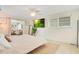 Bedroom featuring a tv, ceiling fan, sliding glass doors, and decor including plants and art at 2565 S Peninsula Dr, Daytona Beach, FL 32118