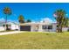 Charming single-story home with a well-manicured lawn, black garage door, and front door at 2565 S Peninsula Dr, Daytona Beach, FL 32118