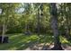 Expansive backyard featuring a fire pit, string lights, and mature trees for a tranquil setting at 261 Clydesdale Cir, Sanford, FL 32773