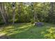 Inviting backyard with green lawn, fire pit, and string lights among mature trees at 261 Clydesdale Cir, Sanford, FL 32773