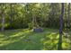 Landscaped backyard featuring a brick fire pit, overhead string lights and mature trees at 261 Clydesdale Cir, Sanford, FL 32773