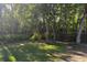 Picturesque backyard featuring mature trees, string lights, and well-maintained greenery at 261 Clydesdale Cir, Sanford, FL 32773