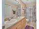 Bright bathroom featuring double sinks, a decorative shower curtain, and neutral tones at 261 Clydesdale Cir, Sanford, FL 32773