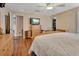 Bedroom featuring hardwood floors, ceiling fan, and large television at 261 Clydesdale Cir, Sanford, FL 32773