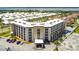 Aerial view of condominium with palm trees, parking, and water views in the distance at 2626 S Atlantic Ave # 1080, Daytona Beach, FL 32118