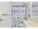 Cozy bathroom with a seashell themed shower curtain, bright vanity, and neutral-toned tiling at 2626 S Atlantic Ave # 1080, Daytona Beach, FL 32118