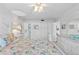 Bright bedroom featuring light walls, ceiling fan, and a charming bed with colorful seashell patterned bedding at 2626 S Atlantic Ave # 1080, Daytona Beach, FL 32118