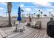 Outdoor dining area with condo pool view, ample seating, and barbecue grilling at 2626 S Atlantic Ave # 1080, Daytona Beach, FL 32118