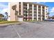 Condo building and parking area with clearly marked parking spots and a grassy area at 2626 S Atlantic Ave # 1080, Daytona Beach, FL 32118