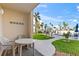 Charming patio with outdoor seating and scenic views of palm trees, pool, and blue skies at 2626 S Atlantic Ave # 1080, Daytona Beach, FL 32118