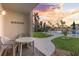 Cozy condo patio with a table set overlooking the pool and a beautiful pink and orange sunset at 2626 S Atlantic Ave # 1080, Daytona Beach, FL 32118