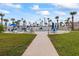 Inviting pool view with multiple chairs for lounging surrounded by landscaping and palm trees at 2626 S Atlantic Ave # 1080, Daytona Beach, FL 32118