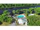 An aerial view of a community pool with a riverside pier and a covered clubhouse with surrounding trees at 2635 Wood Duck Vlg, Deland, FL 32720