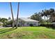 Inviting single-story home featuring a manicured lawn, mature trees, and a welcoming facade under a clear blue sky at 2635 Wood Duck Vlg, Deland, FL 32720