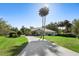Charming single-story home with a long driveway, lush lawn, and mature palm trees in a serene setting under a clear blue sky at 2635 Wood Duck Vlg, Deland, FL 32720