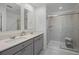 Modern bathroom featuring double sinks, quartz counters, and a glass-enclosed shower at 2743 Gentle Rain Dr, Davenport, FL 33837