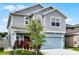 Stylish two-story home with an inviting blue garage door, beautiful plants, and well-maintained landscaping at 2743 Gentle Rain Dr, Davenport, FL 33837