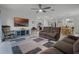 Cozy living room with a plush couch, a ceiling fan, a modern television, and an open view to the eat-in kitchen at 2743 Gentle Rain Dr, Davenport, FL 33837