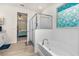 Bathroom featuring a glass shower, soaking tub with brass fixtures, and view into the main bedroom at 2901 Monaghan Dr, Ormond Beach, FL 32174