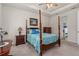 Relaxing primary bedroom with a four-poster bed, tray ceiling, and a view into the ensuite bathroom at 2901 Monaghan Dr, Ormond Beach, FL 32174