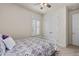 Bedroom featuring carpet, shuttered windows, ceiling fan, and a metal frame bed with patterned bedding at 2901 Monaghan Dr, Ormond Beach, FL 32174