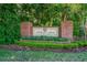 Welcoming brick community entrance sign amidst lush landscaping and mature trees at 2901 Monaghan Dr, Ormond Beach, FL 32174