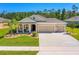 Charming single-story home with a well-manicured lawn, a three-car garage, and a welcoming front porch at 2901 Monaghan Dr, Ormond Beach, FL 32174