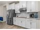 Modern kitchen features stainless steel appliances, white cabinets, and a stylish tile backsplash at 2901 Monaghan Dr, Ormond Beach, FL 32174