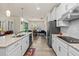 Elegant kitchen boasts stainless appliances, granite counters and bar seating, connecting to the bright dining room at 2901 Monaghan Dr, Ormond Beach, FL 32174