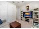 Living room with a sunset-themed TV, gray sofa, leather ottoman, and built-in shelving at 2901 Monaghan Dr, Ormond Beach, FL 32174