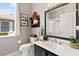Bright bathroom with large mirror, dark vanity, and a shower, complemented by natural light from the window at 3140 Kailani Ct, Ormond Beach, FL 32174