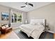 Cozy bedroom with a comfortable bed, soft lighting, and a large window providing a wooded view at 3140 Kailani Ct, Ormond Beach, FL 32174