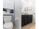 Well-lit bathroom with a toilet, vanity with dark cabinets, and tile flooring at 320 Conch Key Way, Sanford, FL 32771