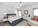 Serene bedroom with a gray upholstered bed, white dressers, and soft, natural light at 320 Conch Key Way, Sanford, FL 32771