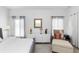 Bright bedroom featuring a large window with curtains, dresser, and sitting area with ottoman at 320 Conch Key Way, Sanford, FL 32771
